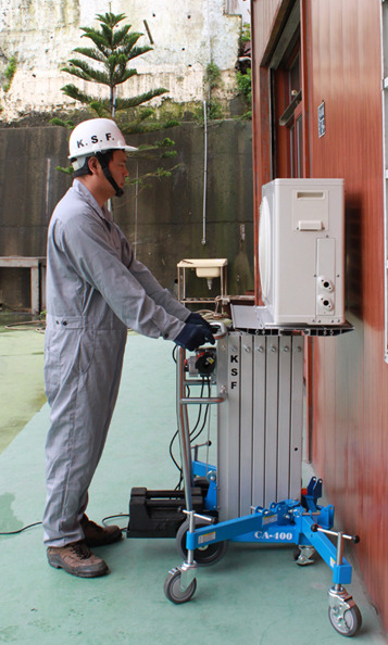 CA400 Super Lifter raising an air conditioning condenser to a wall mount, operated by one person